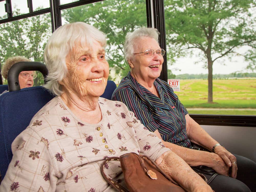 Residents Smiling On Bus Trip Outing