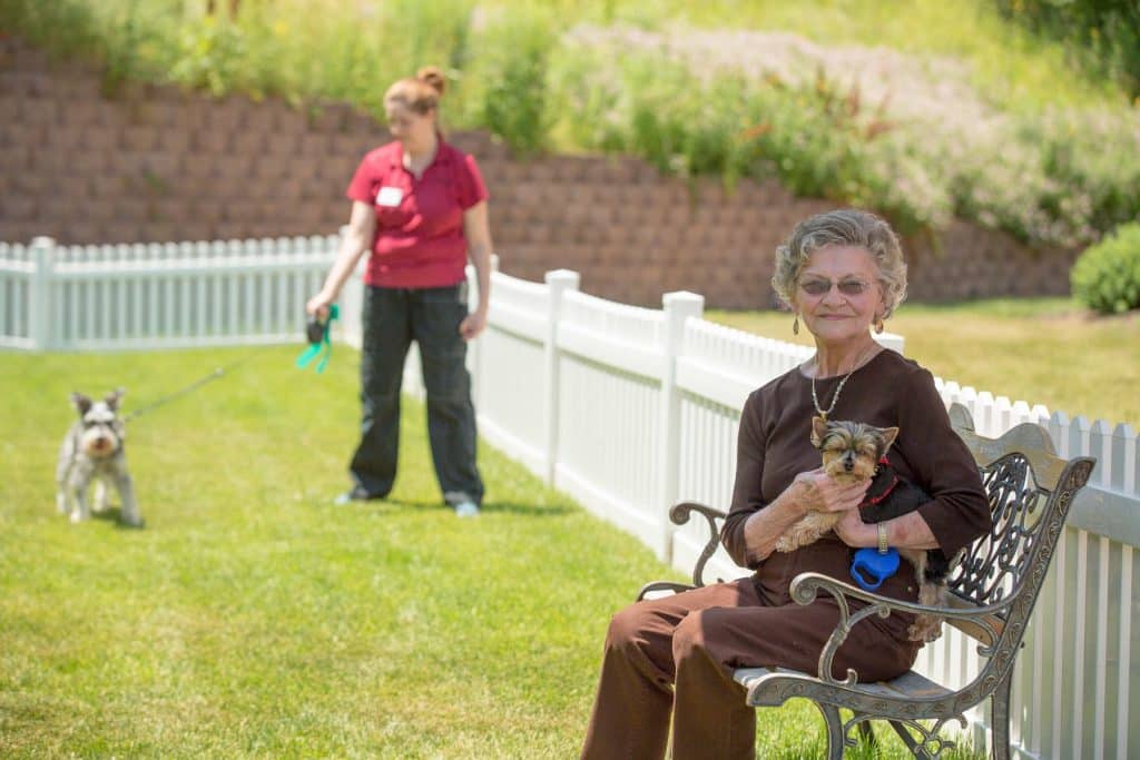 Resident Smiling With Her Dog Outside