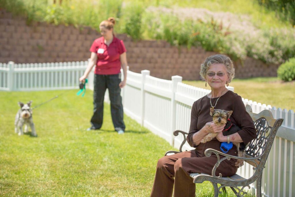 Resident Smiling With Her Dog Outside