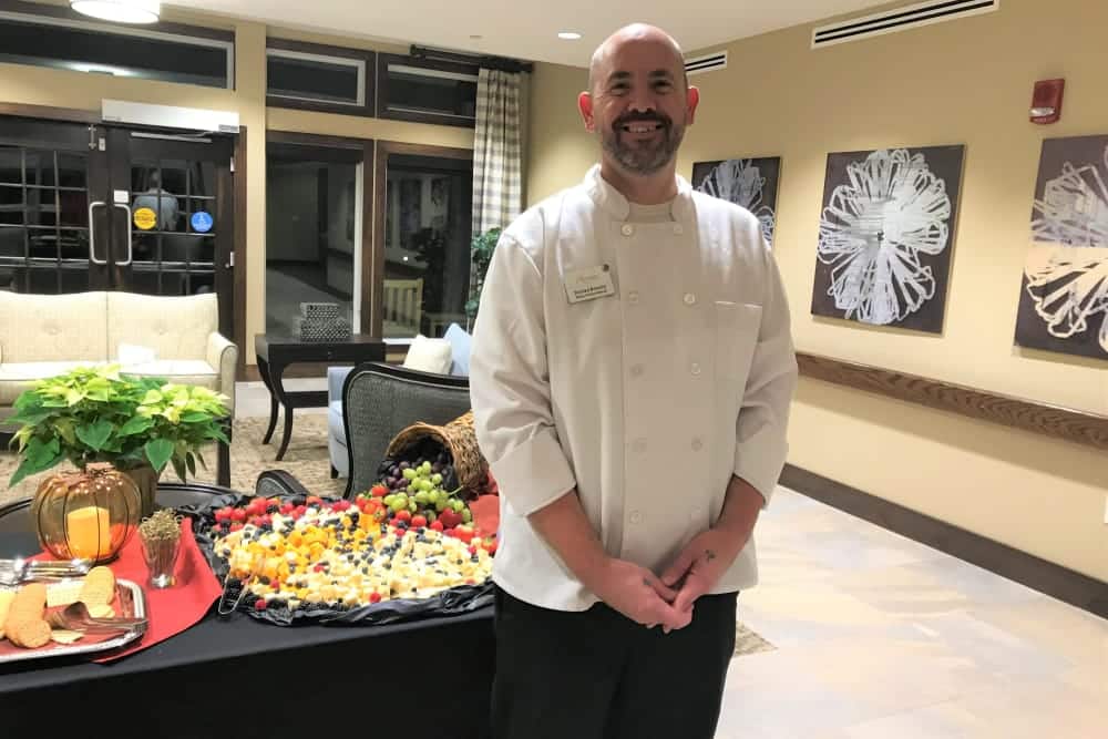 Chef Smiling At Event With Delicious Food