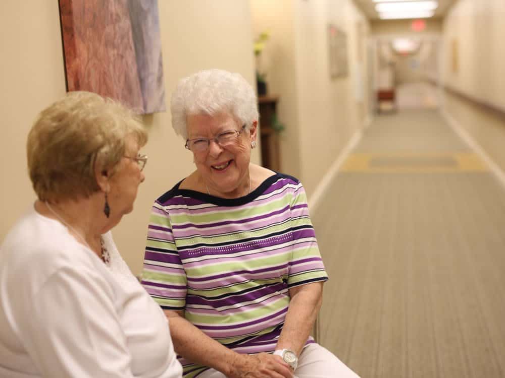Two Women Having Conversation In Hallway