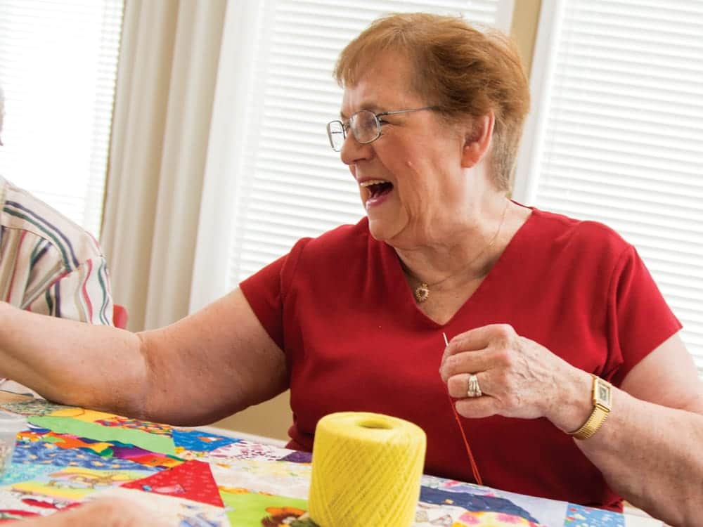 Resident Smiling While Quilting