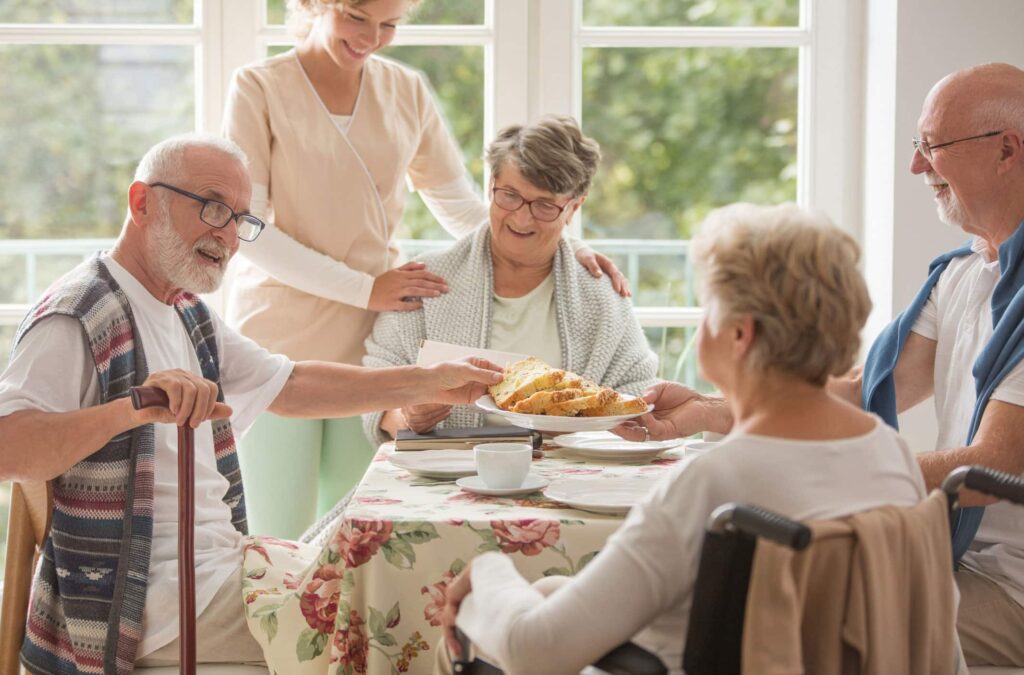 group of 4 senoirs gathered around a table eating breakfast