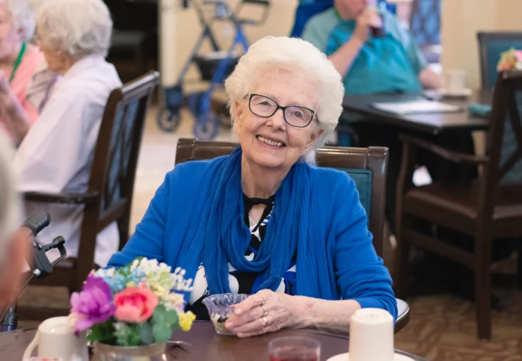 A resident at Orchard Pointe at Arrowhead sitting a table in dining room