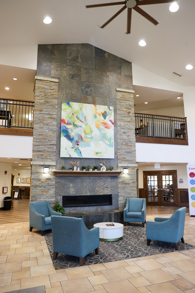 The Heritage at Legacy lobby fireplace with chairs.