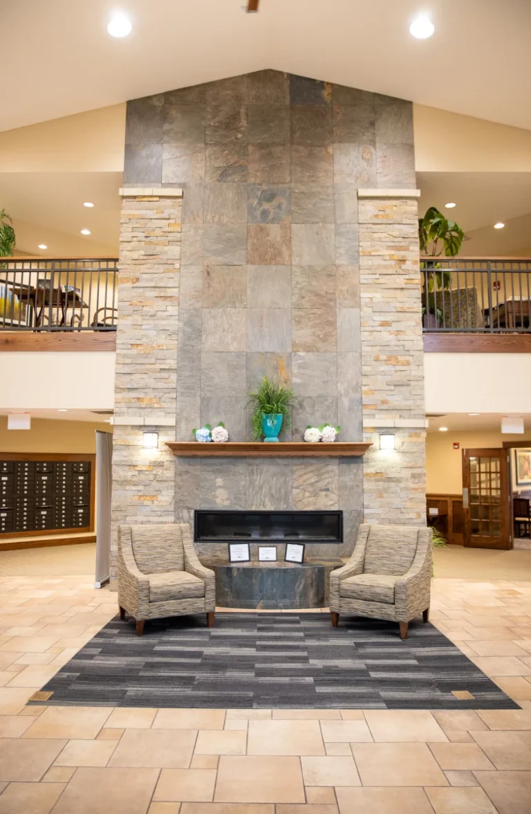 The Heritage at Legacy lobby fireplace with chairs.