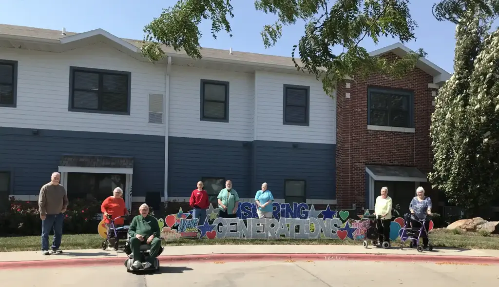 Fountain View Senior Living residents outside in front of a yard sign