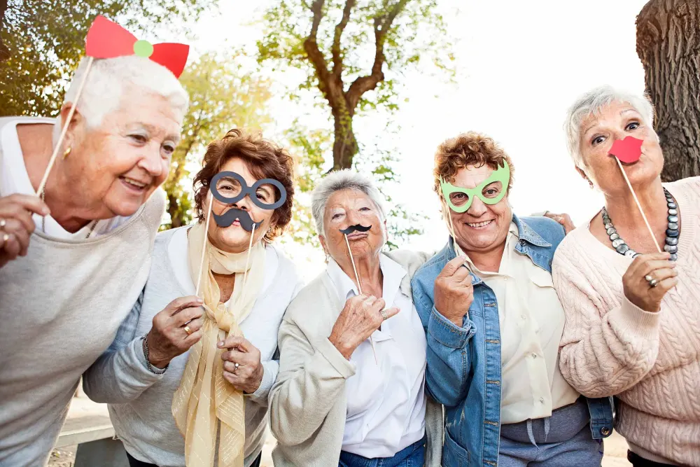 A group of seniors being playful with masks and props
