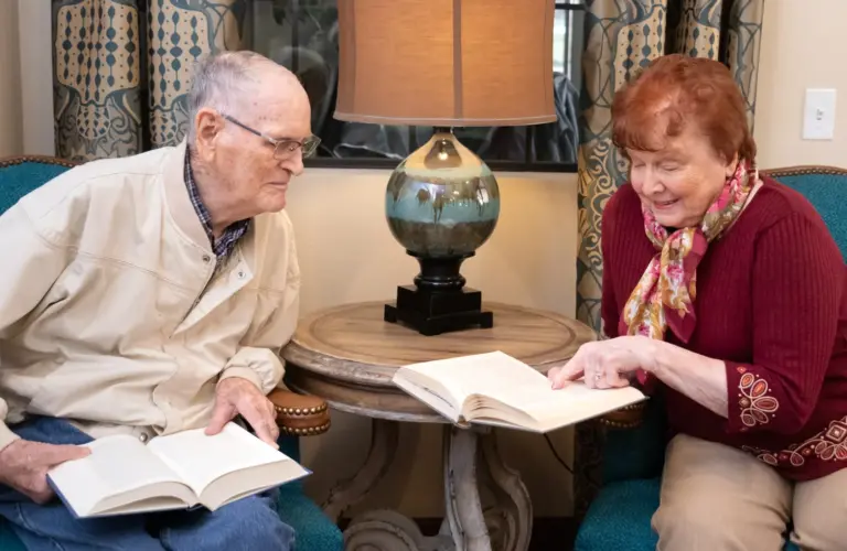 A couple from Orchard Pointe at Arrowhead senior living reading books together