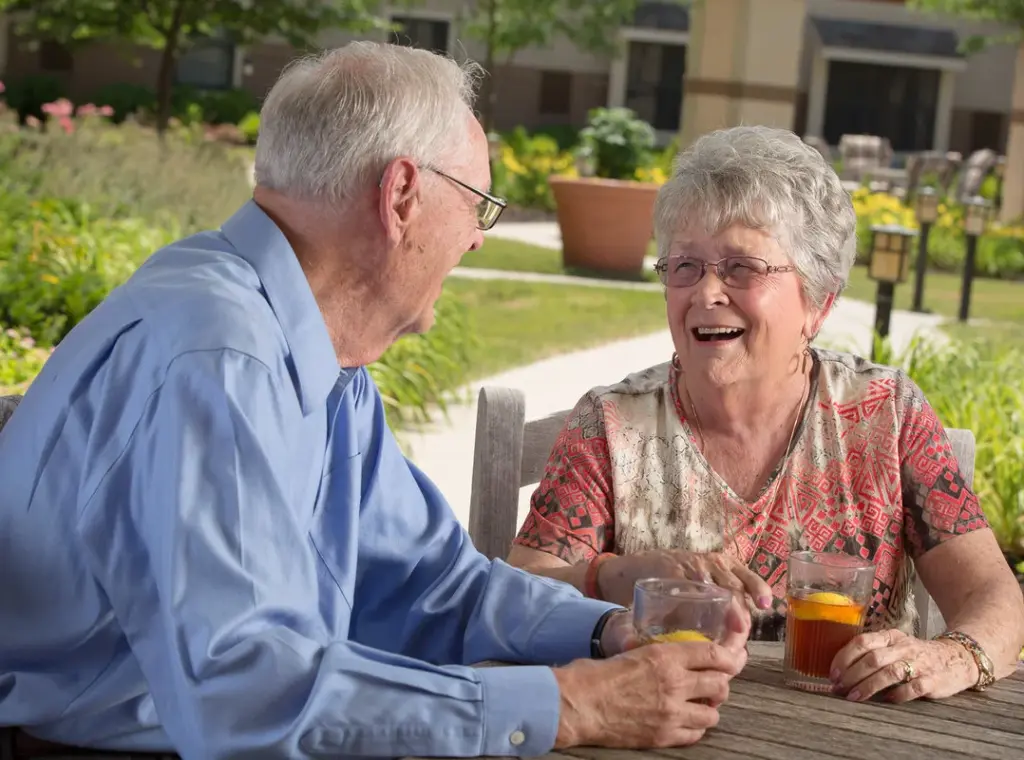 A senior couple have a drink outside at Heritage Ridge retirement community