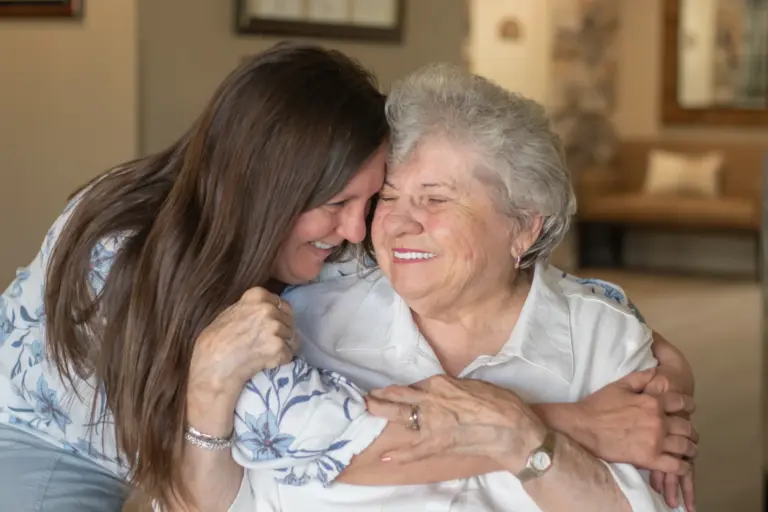 A resident and a Heritage associate embrace Orchard Pointe at Surprise retirement community
